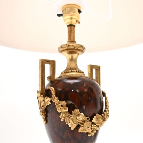 fig 1. A pair of French Neoclassical table lamps crafted from dark red marble urns with gilt bronze foliage garlands and pleated cream shades.
