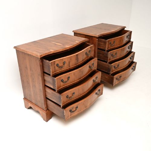 fig 1. A matching pair of Georgian-style yew wood chests of drawers with serpentine fronts, brass handles, and four drawers each.