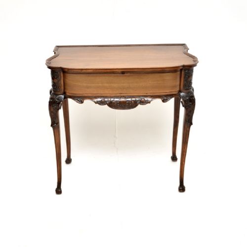 fig 1. An antique Victorian carved walnut console table featuring a serpentine front, detailed apron carvings, and slender cabriole legs.
