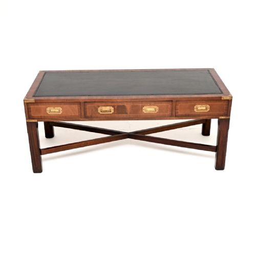 fig 1. A rectangular dark mahogany military campaign style coffee table with an inset black leather top, three drawers with flush brass handles, and an X-frame cross stretcher base.