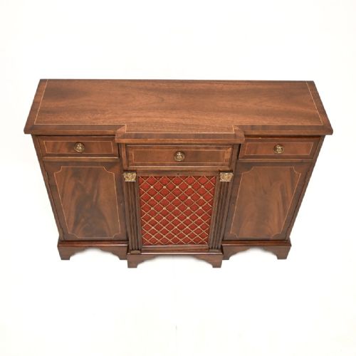 fig 1. A Georgian style mahogany sideboard with boxwood stringing, featuring a central drawer above a brass lattice grille door backed with red fabric, flanked by drawers and cupboard doors.