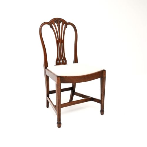 fig 1. A set of eight dark mahogany Edwardian dining chairs featuring pierced splat backs and neutral cream fabric upholstered seats.