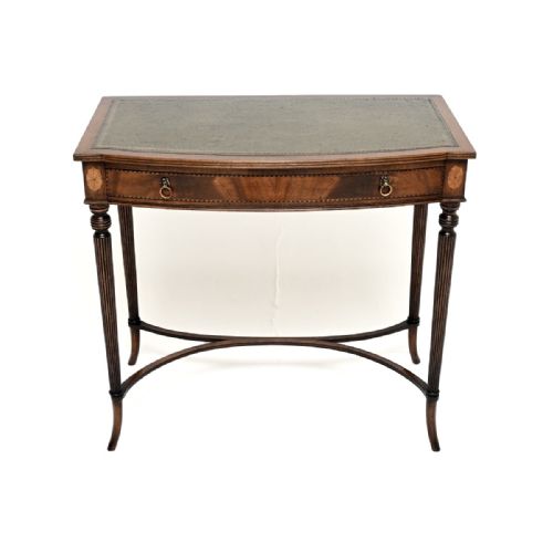 fig 1. An antique mahogany writing table featuring a green leather top, fine marquetry inlays, a single drawer with ring handles, and slender reeded legs connected by a curved X-stretcher.