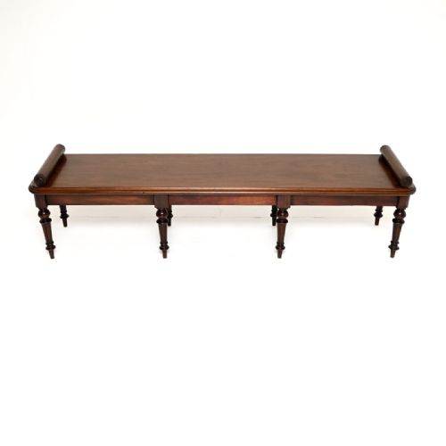 fig 1. A long antique Victorian mahogany hall bench featuring raised bolster ends and multiple turned legs.