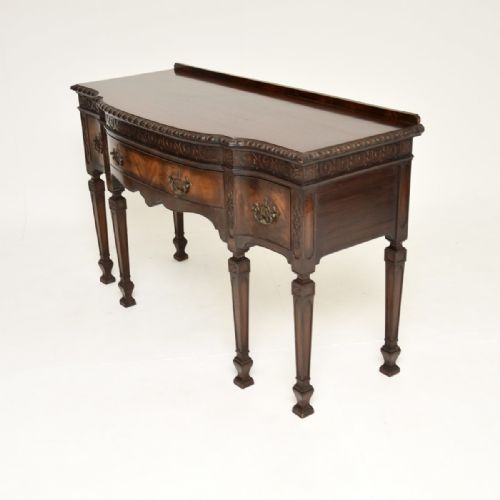 fig 1. A dark mahogany Georgian style console table with a carved scrollwork frieze, brass drop handles, and turned legs.