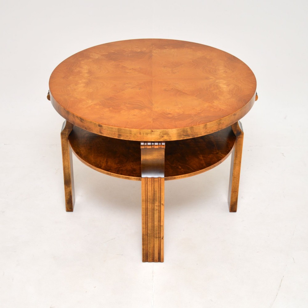 A circular Scandinavian Art Deco coffee table featuring matched satin birch veneer, a lower tier shelf, and reeded legs.