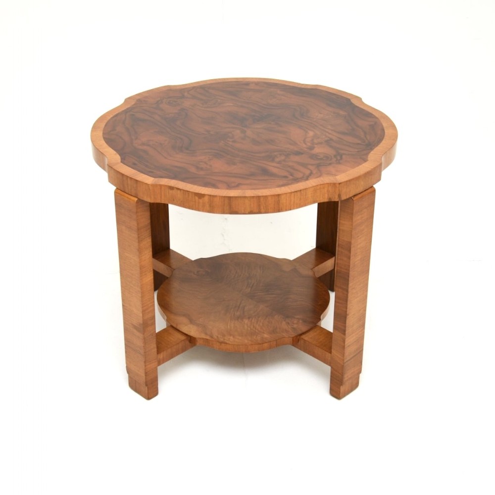 An Art Deco figured walnut occasional table featuring a scalloped top surface, square legs, and a lower tier shelf.