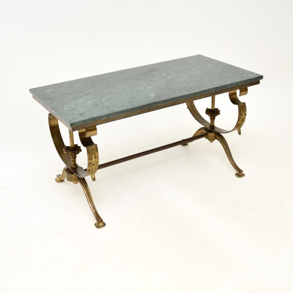 A rectangular French coffee table featuring a green marble top resting on a brass frame with curved legs and acanthus leaf ornamentation.