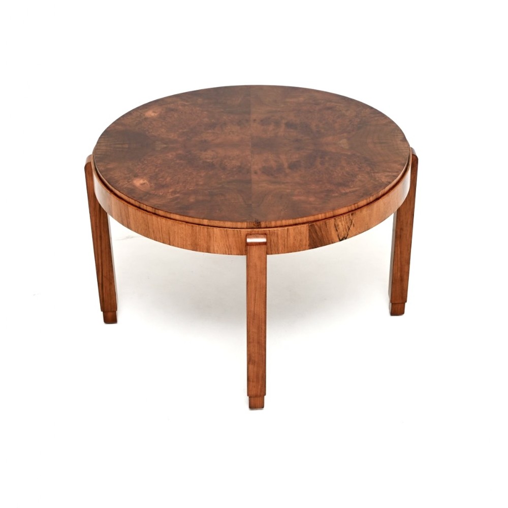 A circular Art Deco coffee table crafted from figured burr walnut veneer with four straight legs and a deep apron.