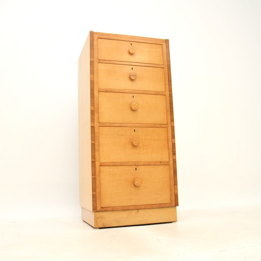 A tall Art Deco sycamore chest of drawers featuring five vertical drawers with circular wooden handles and darker wood framed borders.