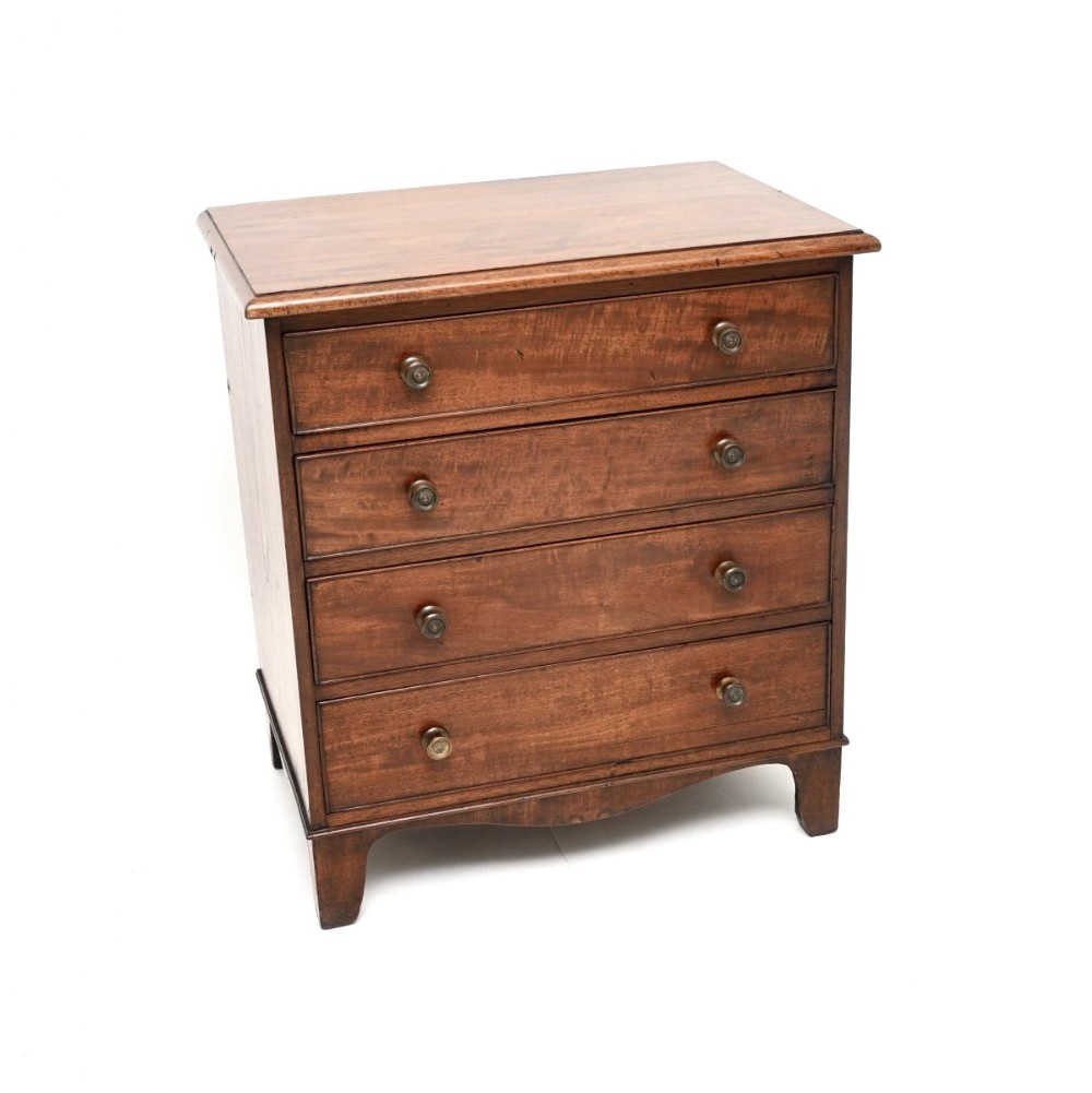 An antique Georgian mahogany chest featuring four graduated drawers with turned knobs, resting on shaped bracket feet.