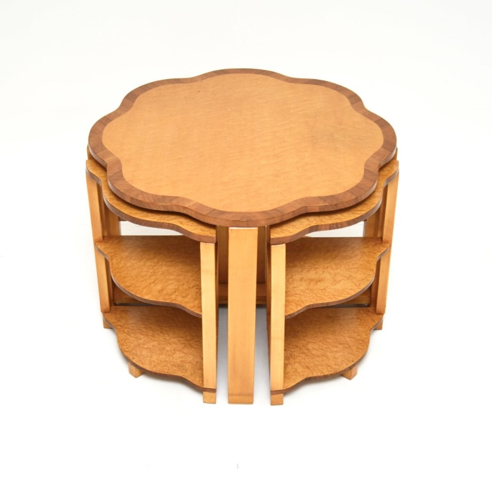 An Art Deco nest of coffee tables featuring a main scalloped top in birds eye maple with darker walnut banding and four fitted quadrant under-tables.