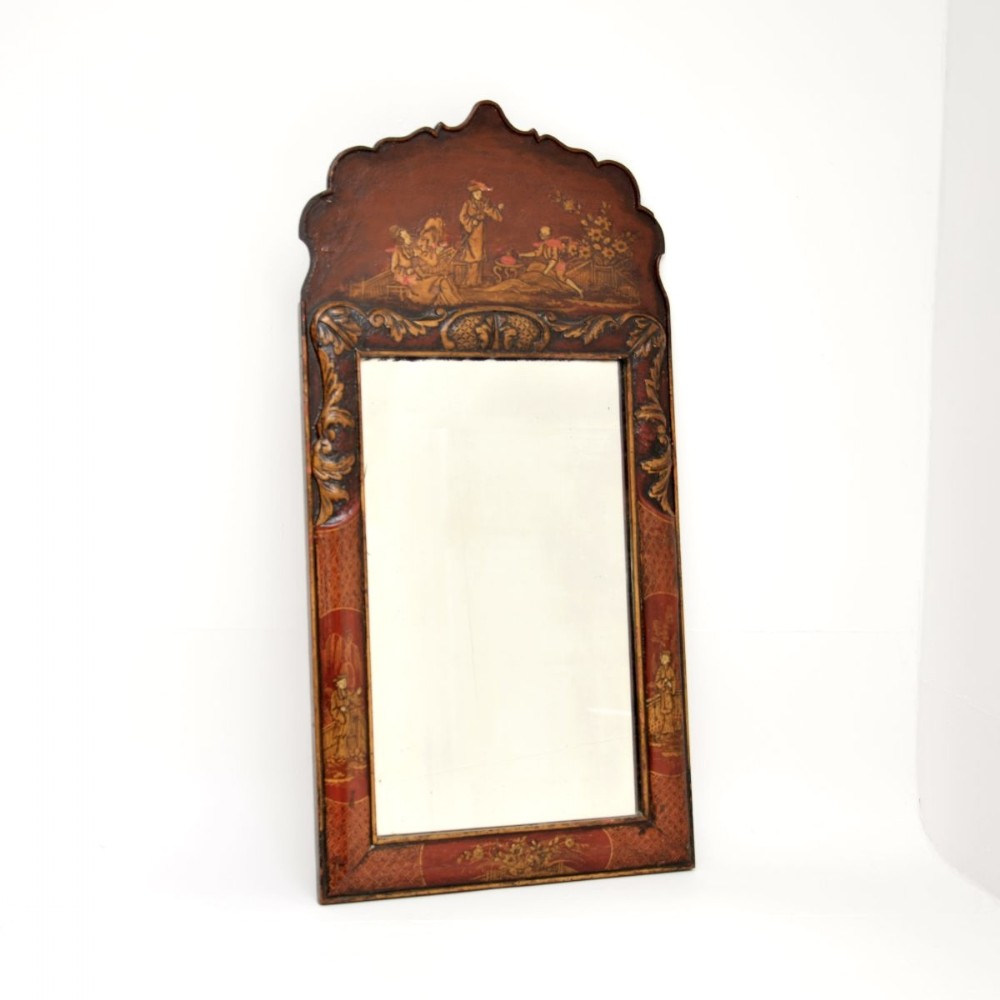 An antique Georgian wall mirror featuring a shaped cresting top decorated with hand-painted red lacquer and gold Chinoiserie figures.