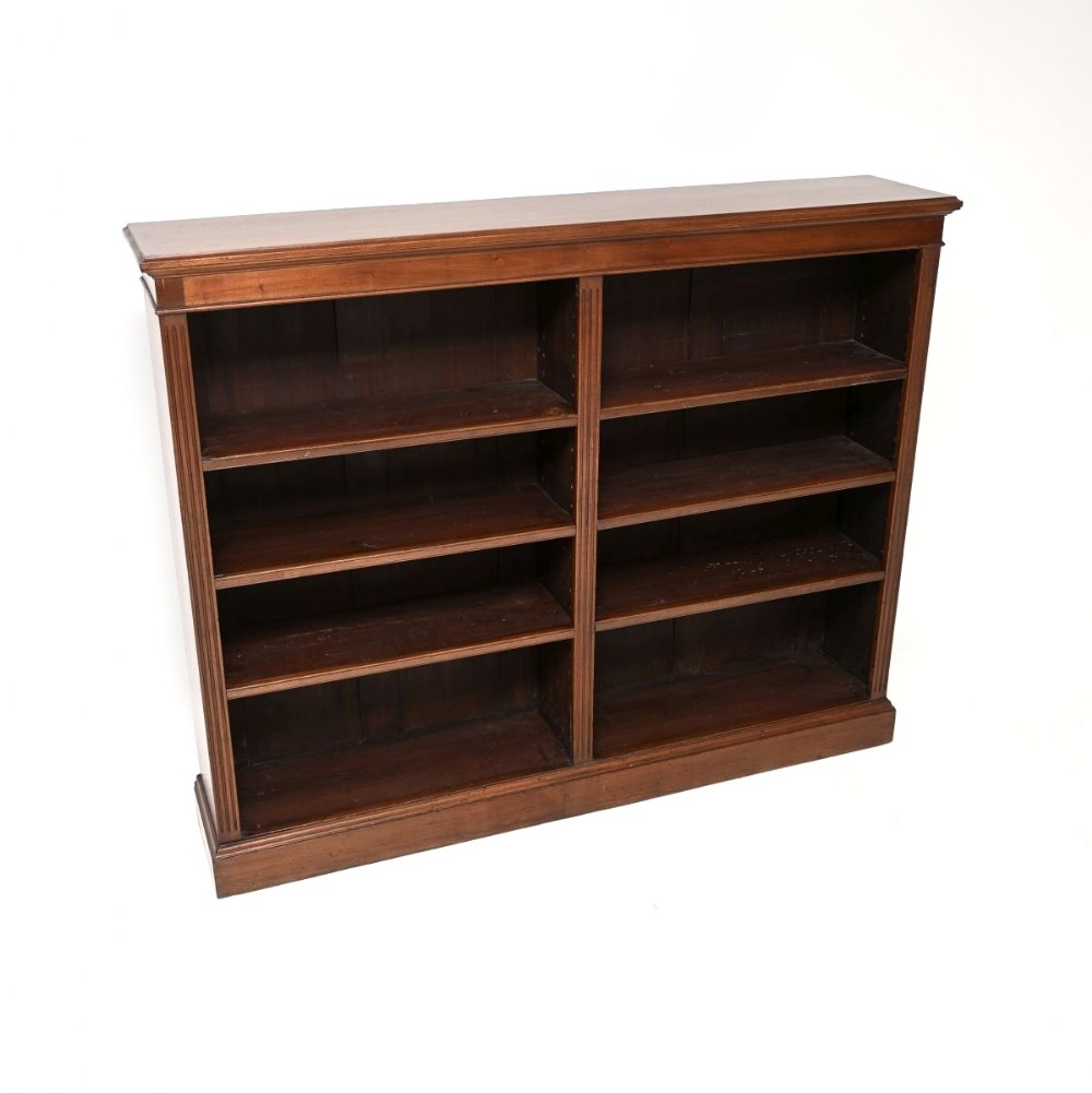 A double-bay Victorian mahogany open bookcase featuring adjustable shelves, fluted side pilasters, and a plinth base.