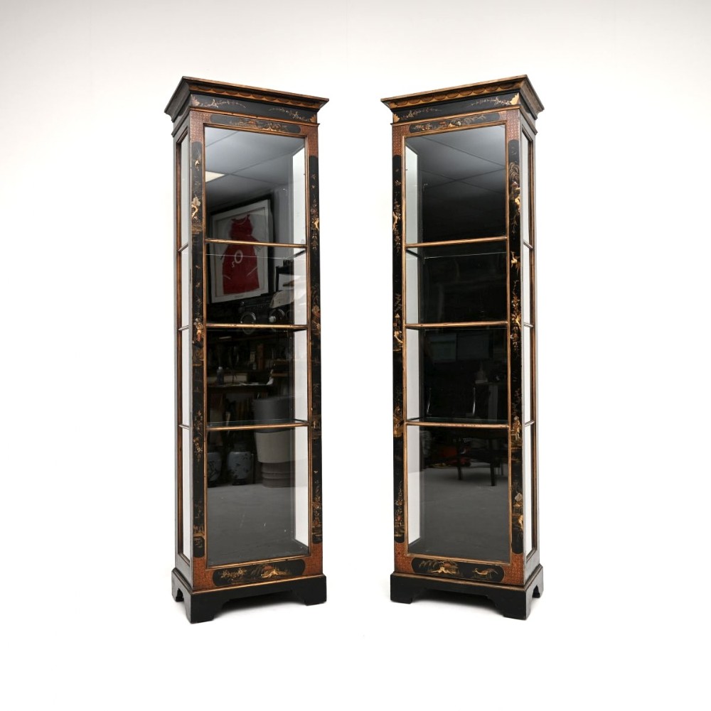 A pair of tall, narrow Edwardian black lacquered display cabinets with glass doors, glass side panels, and hand-painted gold Chinoiserie detail.