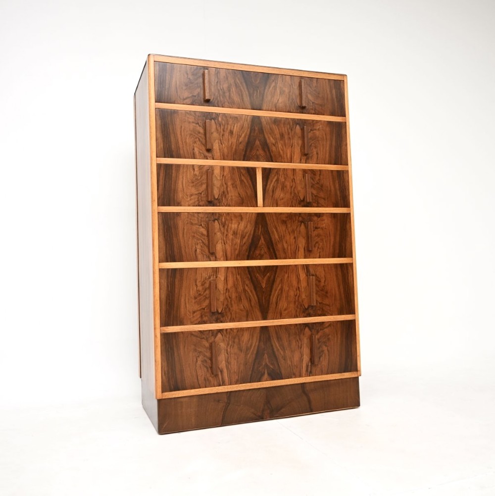 A tall Art Deco chest of drawers constructed with book-matched figured walnut veneer and featuring vertical wooden pulls.