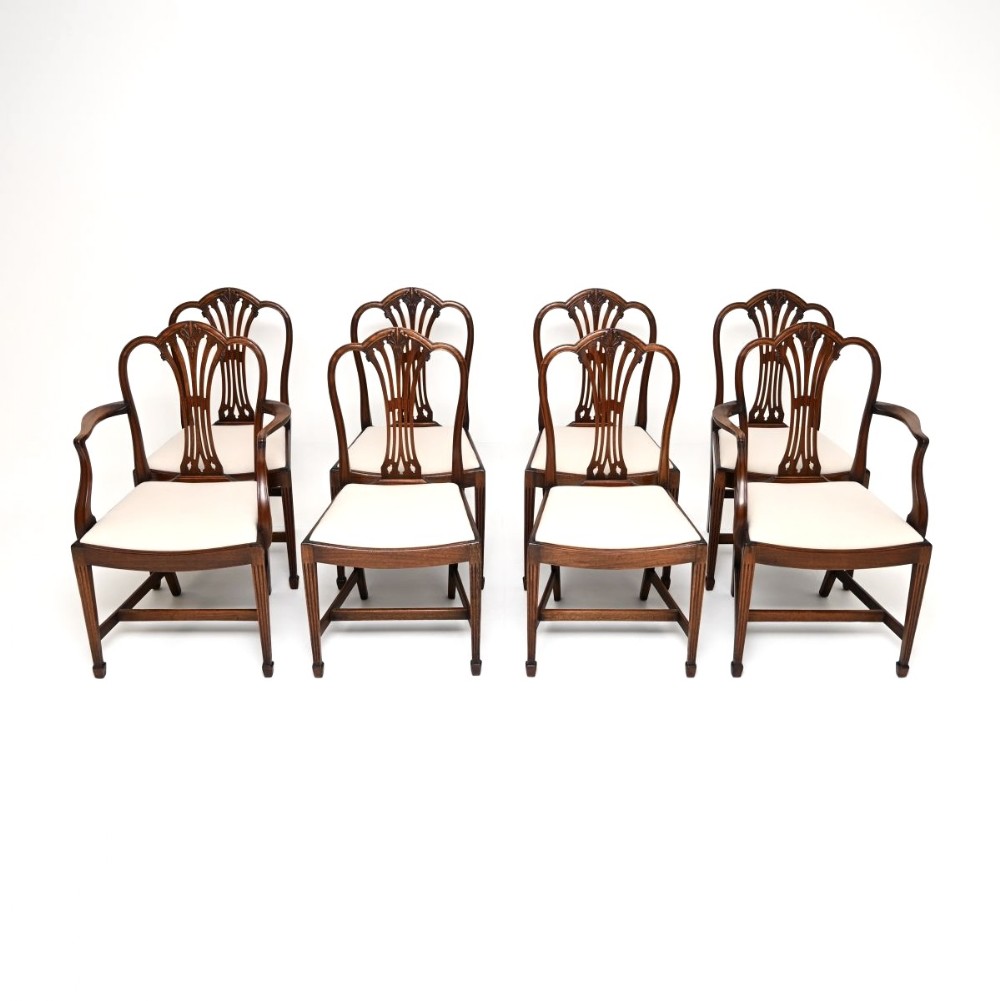 A set of eight dark mahogany Edwardian dining chairs featuring pierced splat backs and neutral cream fabric upholstered seats.