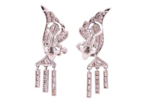 fig 1. A pair of Art Deco platinum earrings set with round and baguette diamonds, featuring winged tops and detachable geometric drop pendants.