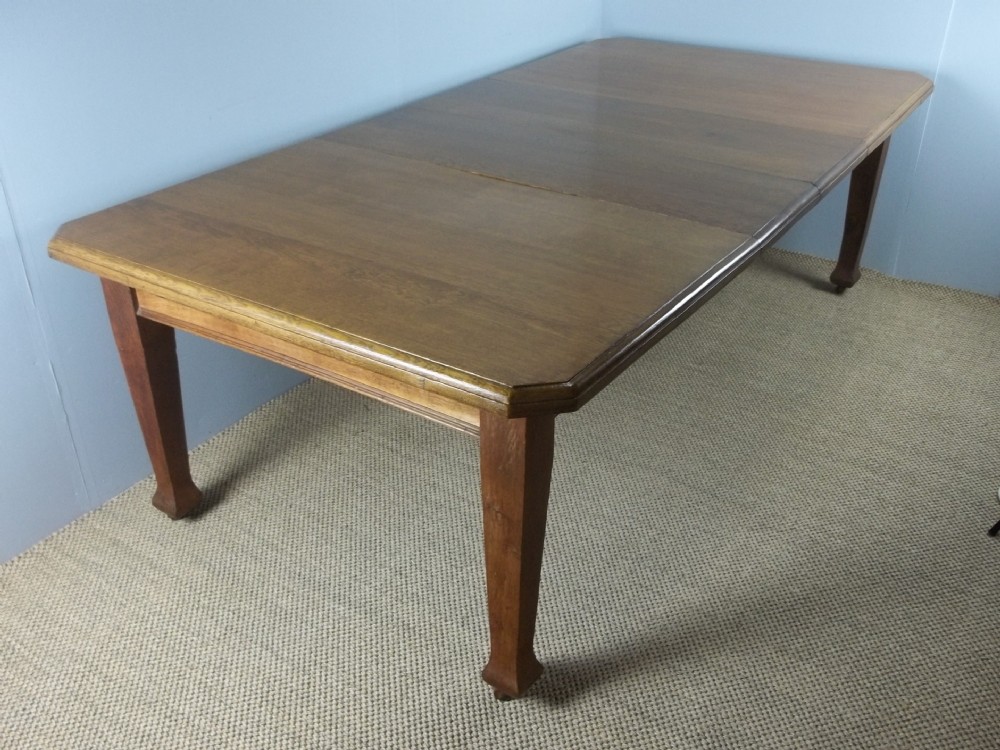 A Large antique oak Arts and Crafts wind out extending eight ten twelve seat dining table. C.1900.