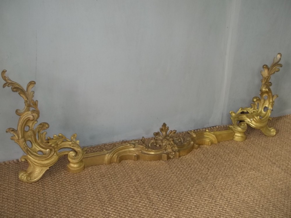 A 19th-century gilt bronze Rococo fireplace fender featuring adjustable scrolling acanthus leaf chenets at each end. View II