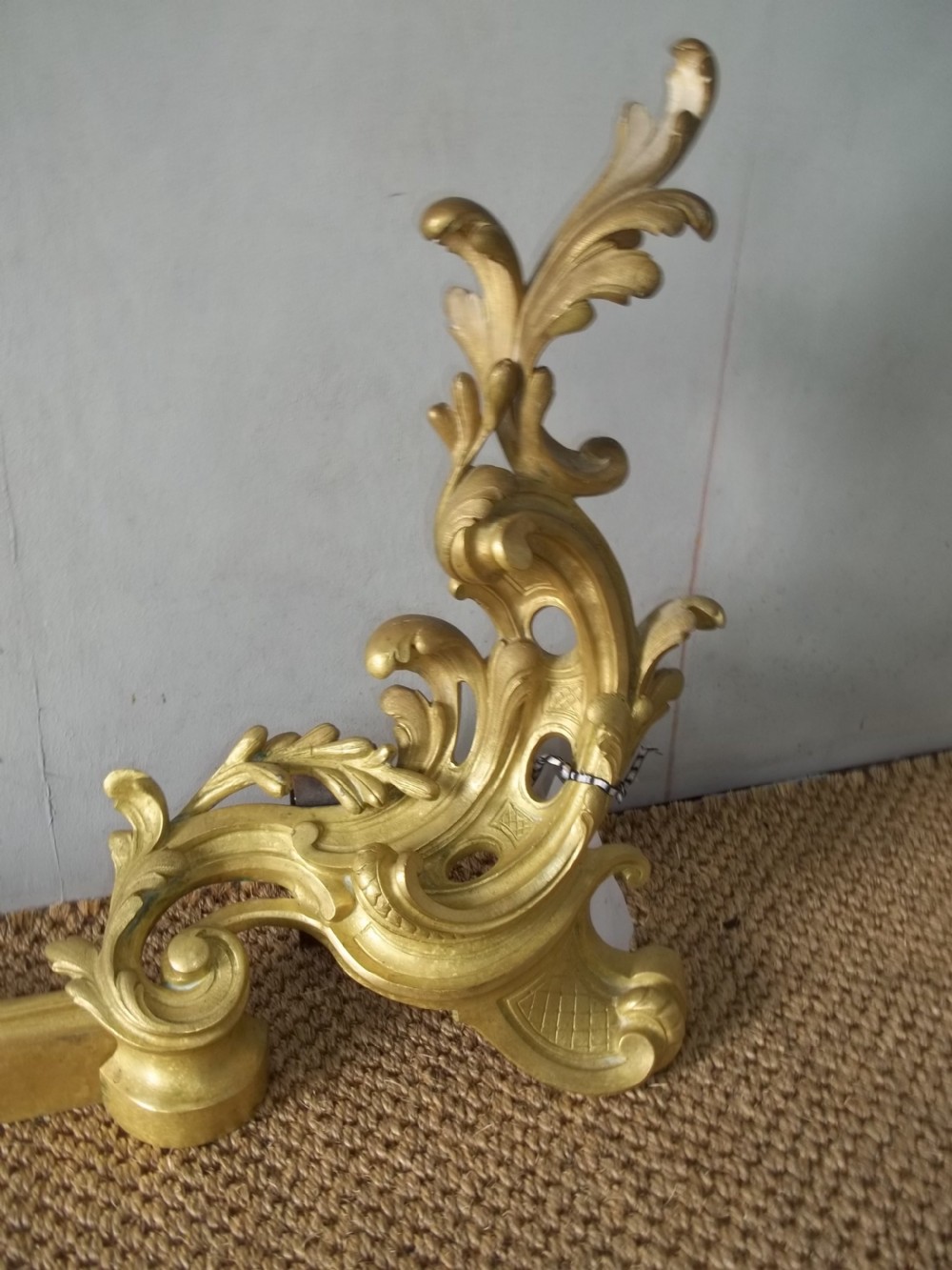 A 19th-century gilt bronze Rococo fireplace fender featuring adjustable scrolling acanthus leaf chenets at each end. View V