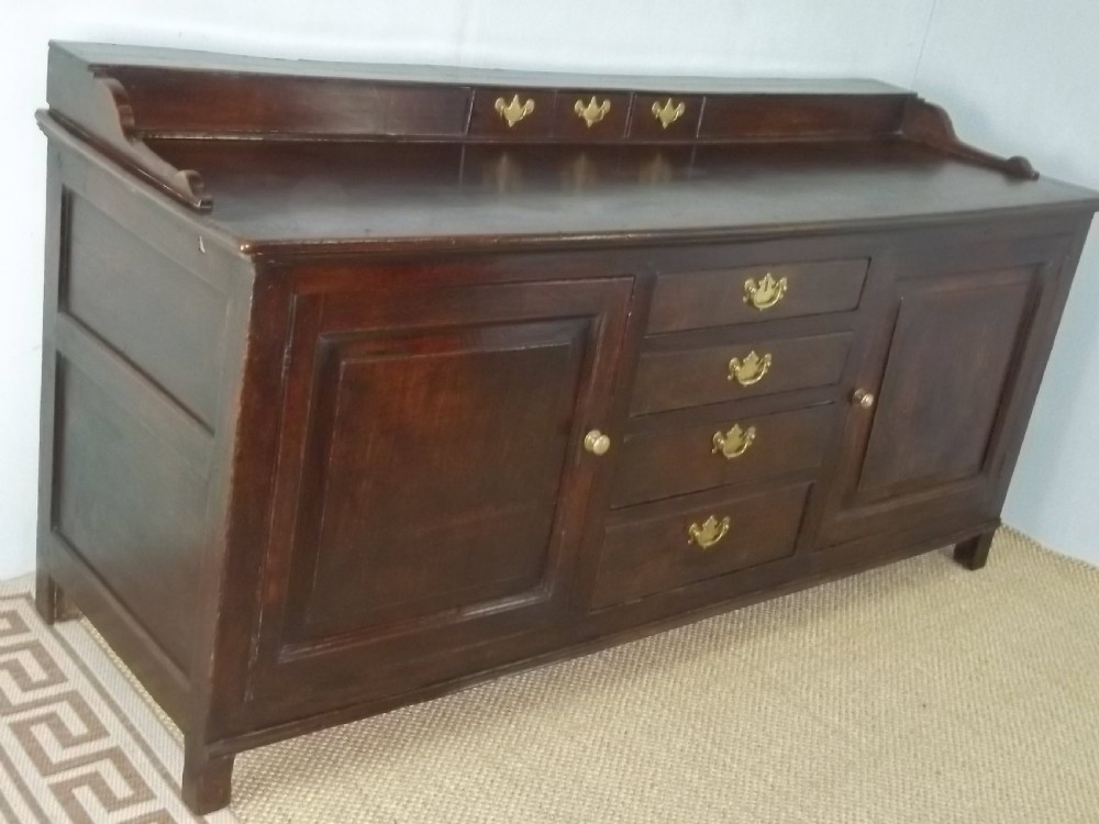 A Welsh Geo II early 18th century Georgian oak dresser base with spice drawers serving table sdieboard. 