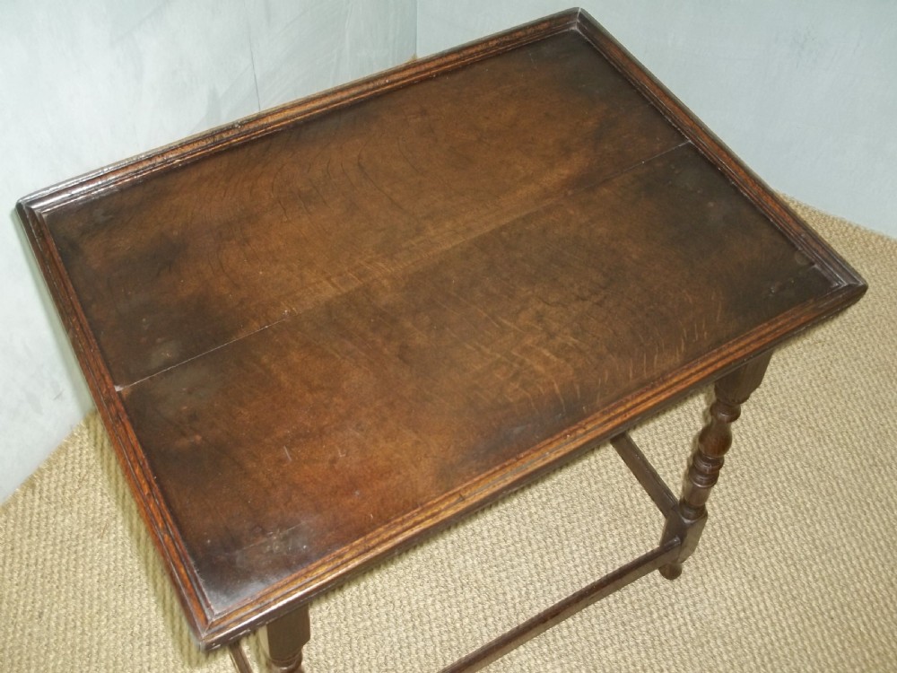 A dark brown oak side table featuring a tray top with a raised moulded rim, turned legs, and a low rectangular box stretcher base. View III