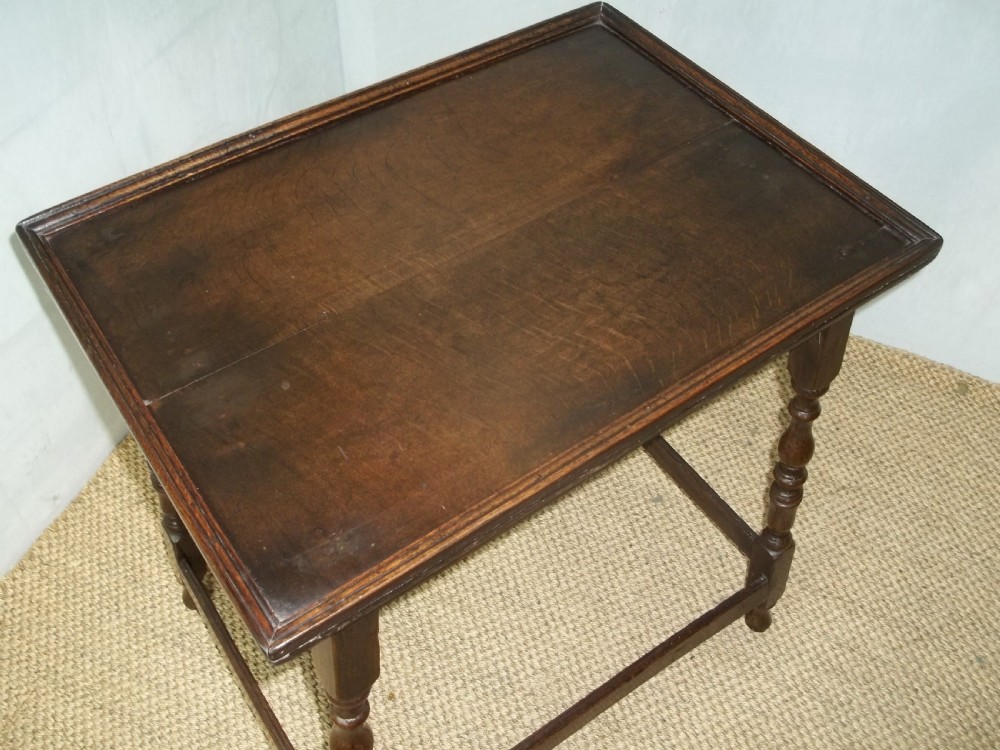 A dark brown oak side table featuring a tray top with a raised moulded rim, turned legs, and a low rectangular box stretcher base. View IV