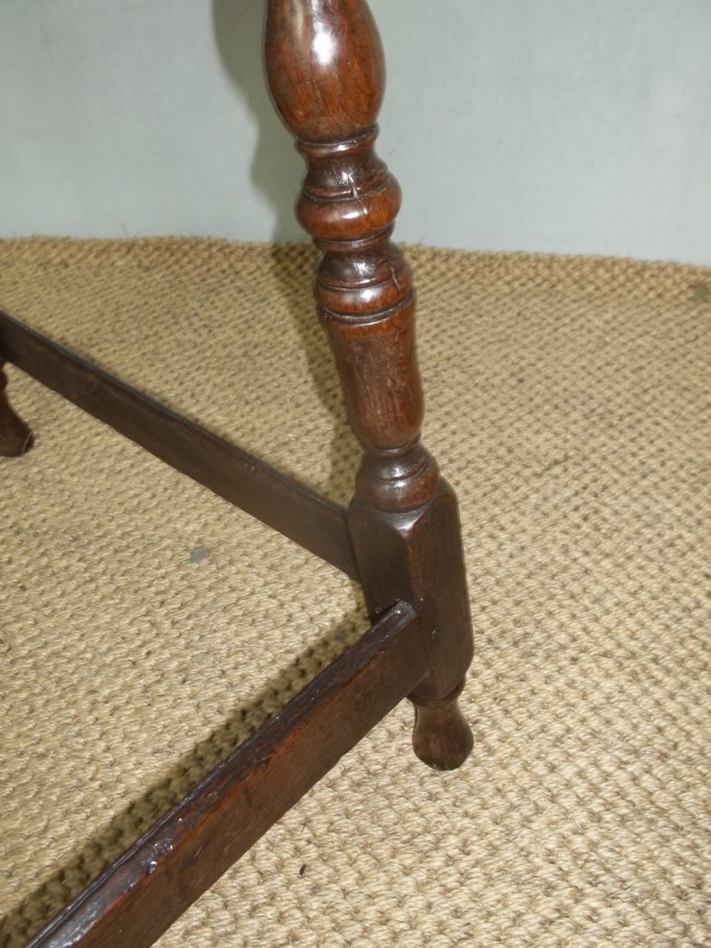 A dark brown oak side table featuring a tray top with a raised moulded rim, turned legs, and a low rectangular box stretcher base. View VI