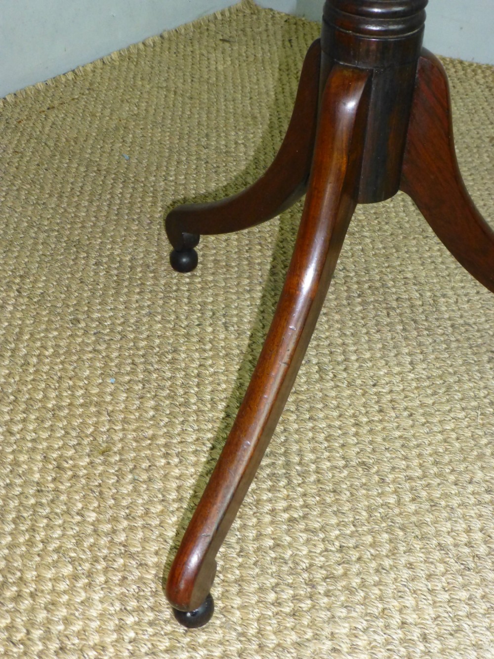 A Regency era rosewood occasional wine table featuring an octagonal top with beaded edging, a turned central pedestal, and three downswept tripod legs. View II