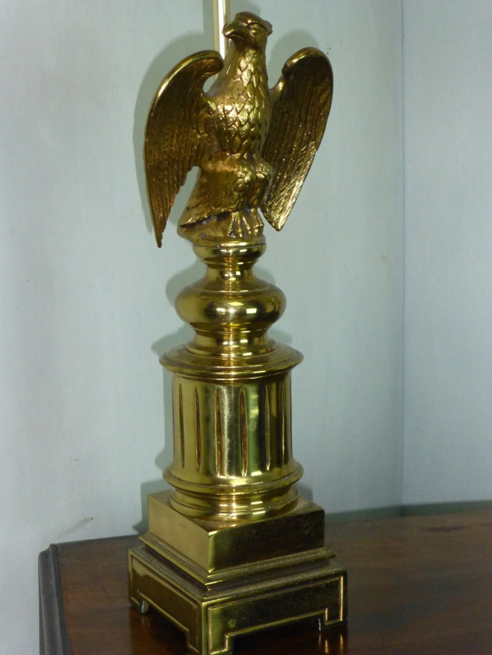 A pair of cast brass table lamps featuring eagle sculptures on stepped pedestal bases with cream pyramid shades. View III