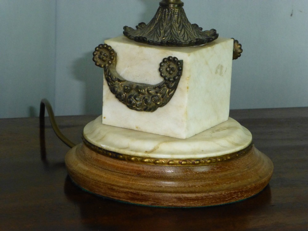 An antique Edwardian table lamp featuring a fluted brass column on a white marble plinth with a pleated cream shade. View III