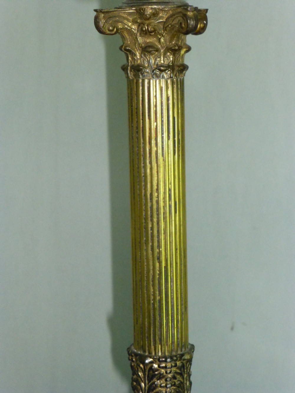 An antique Edwardian table lamp featuring a fluted brass column on a white marble plinth with a pleated cream shade. View IV