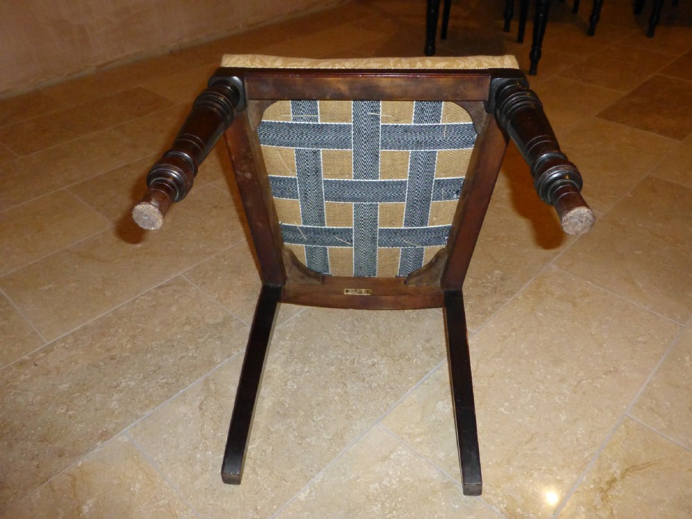 A set of ten 19th-century Victorian dark mahogany dining chairs featuring carved back rails, turned front legs, and yellow patterned fabric upholstered seats. View V