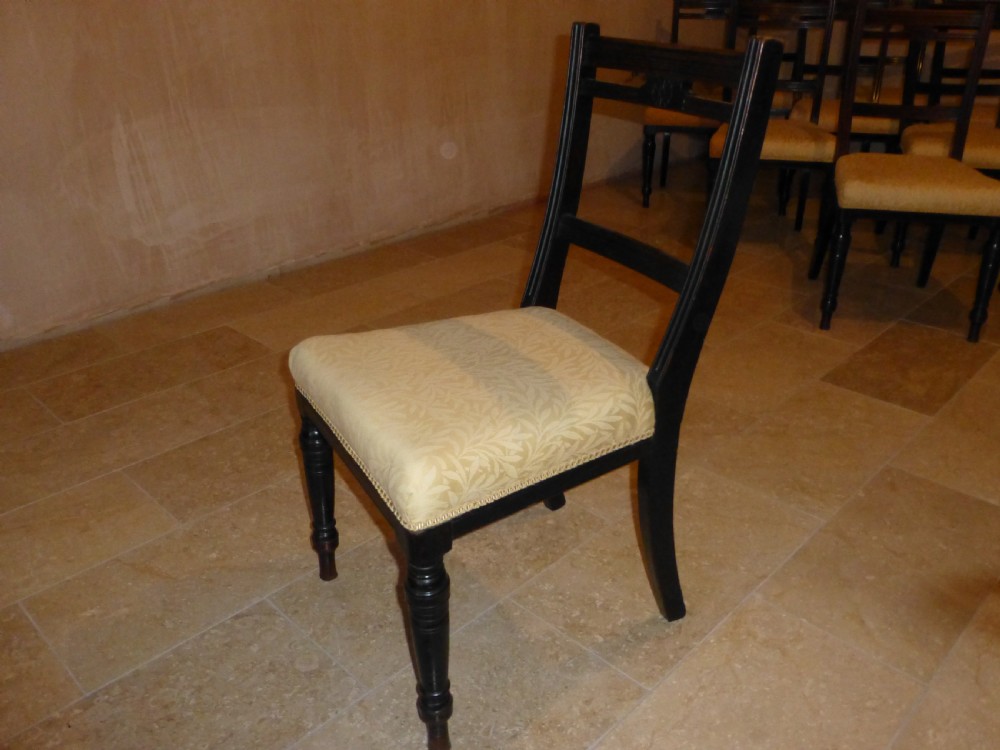 A set of ten 19th-century Victorian dark mahogany dining chairs featuring carved back rails, turned front legs, and yellow patterned fabric upholstered seats. View IX