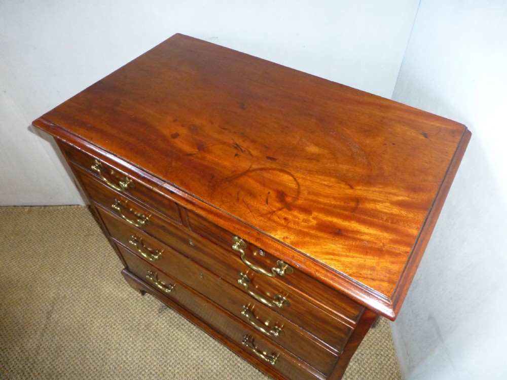 An 18th-century Georgian mahogany chest of drawers featuring two short over three long drawers with brass swan-neck handles and bracket feet. View II