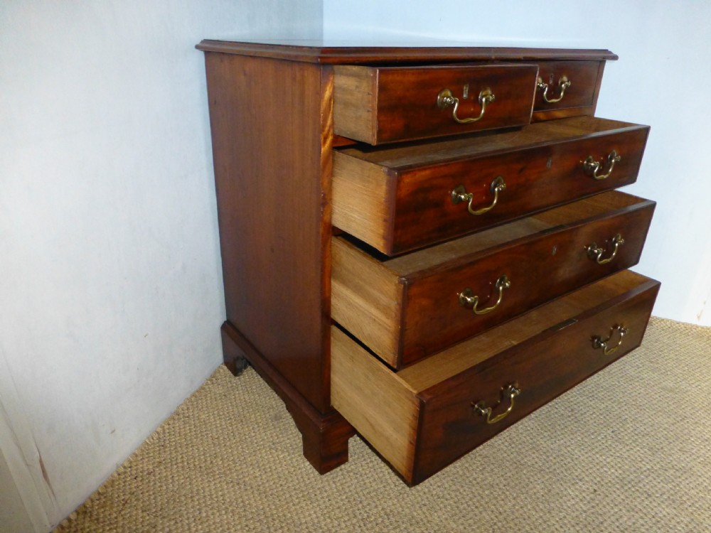 An 18th-century Georgian mahogany chest of drawers featuring two short over three long drawers with brass swan-neck handles and bracket feet. View VII