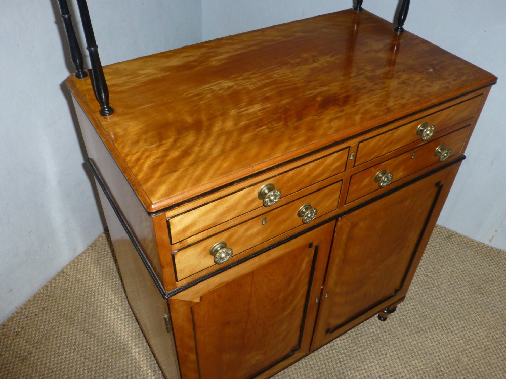 A Regency satinwood chiffonnier desk featuring two tiered upper shelves with ebonised turned supports above drawers and a double cupboard door cabinet. View III