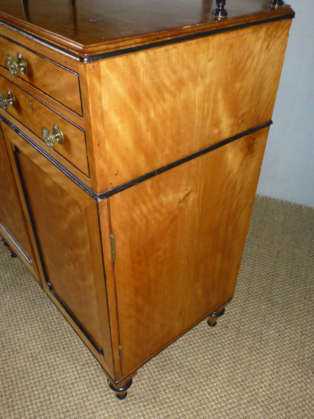 A Regency satinwood chiffonnier desk featuring two tiered upper shelves with ebonised turned supports above drawers and a double cupboard door cabinet. View VI