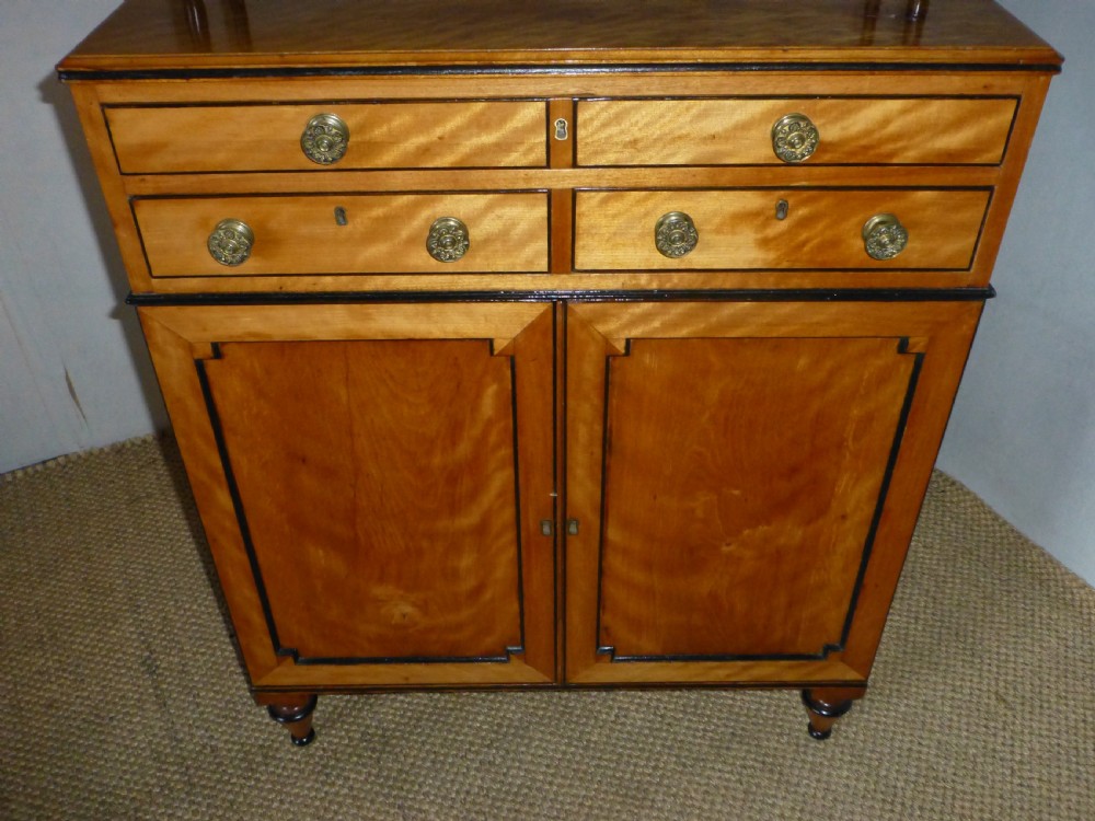 A Regency satinwood chiffonnier desk featuring two tiered upper shelves with ebonised turned supports above drawers and a double cupboard door cabinet. View VII