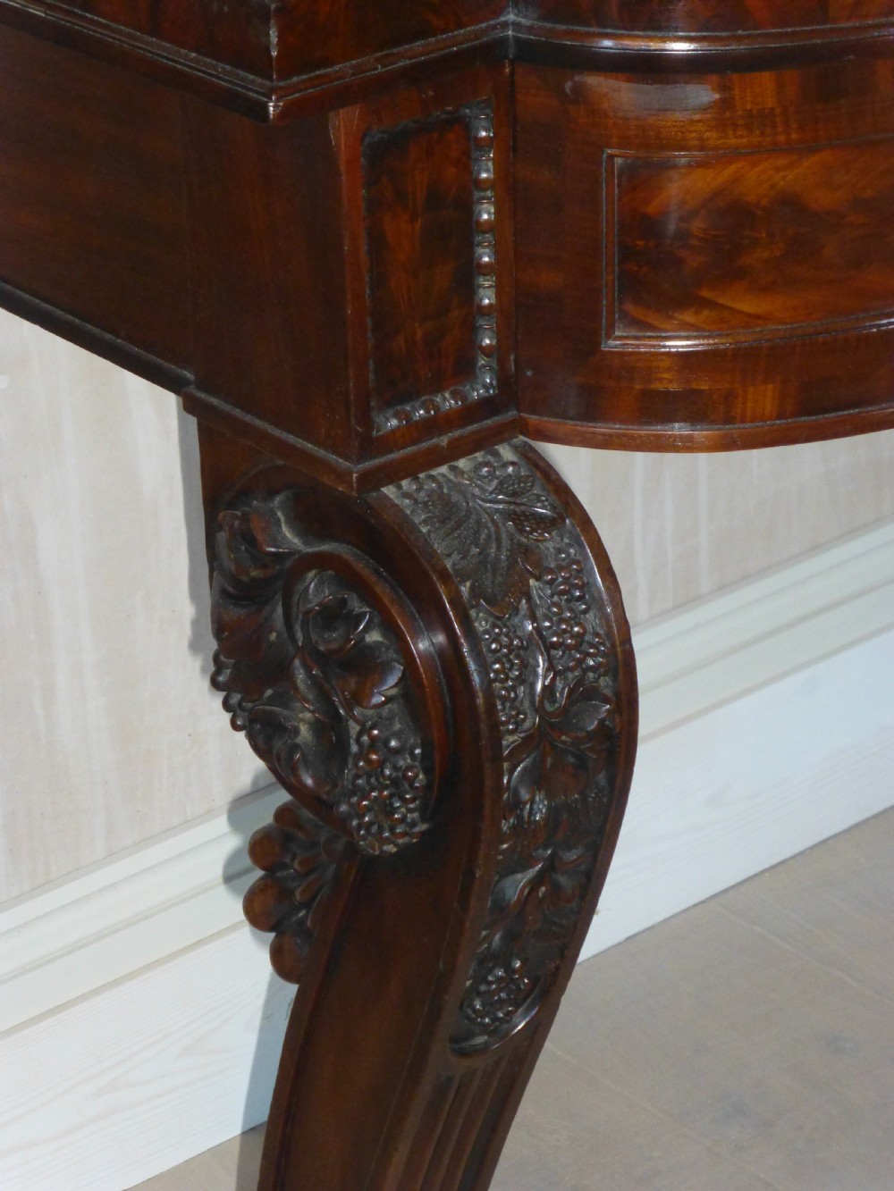 A dark mahogany Regency serving table featuring a scroll-carved backboard, a smooth top surface, and carved scroll front legs. View II