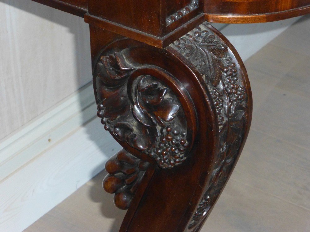 A dark mahogany Regency serving table featuring a scroll-carved backboard, a smooth top surface, and carved scroll front legs. View III