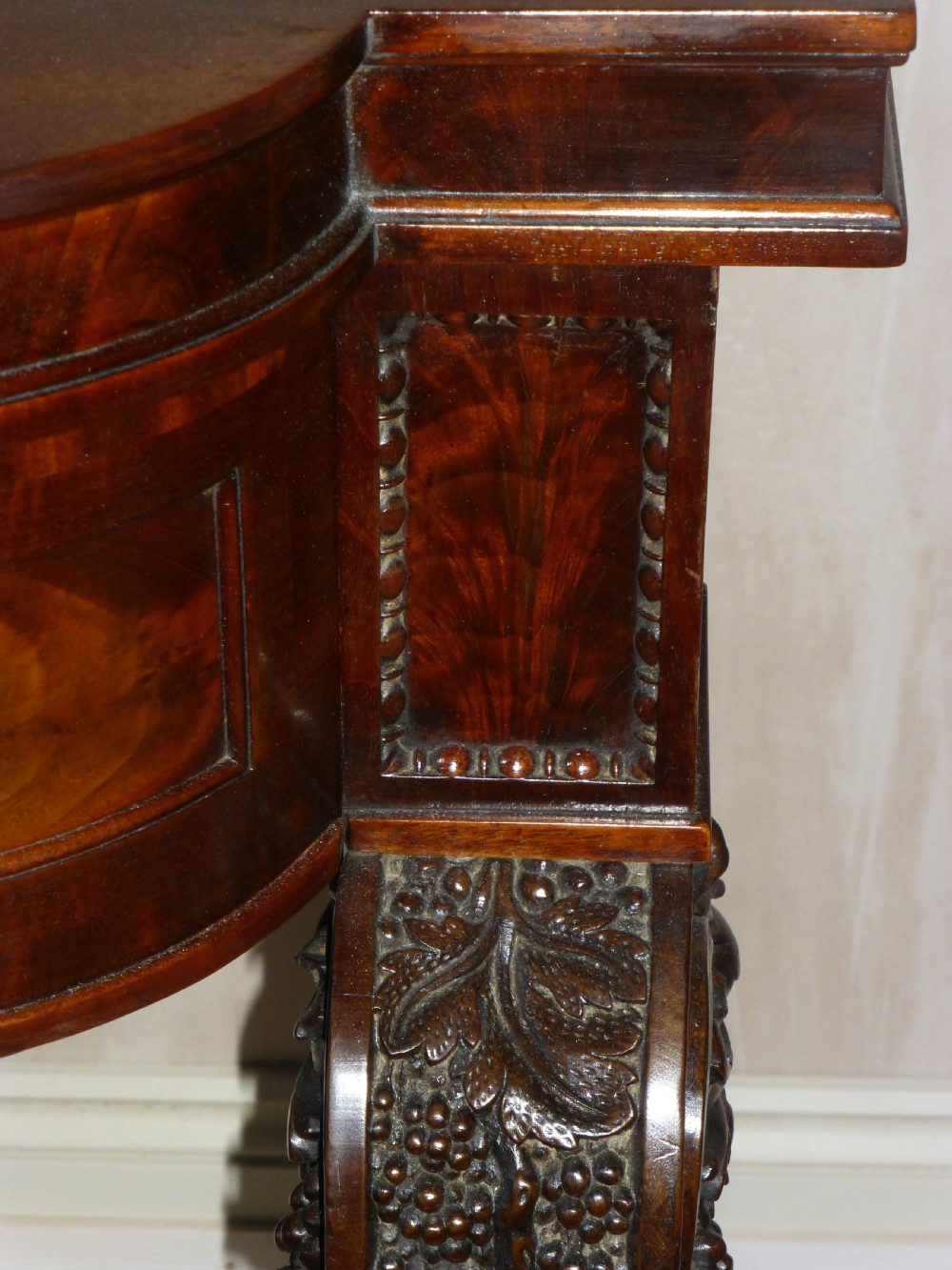 A dark mahogany Regency serving table featuring a scroll-carved backboard, a smooth top surface, and carved scroll front legs. View V