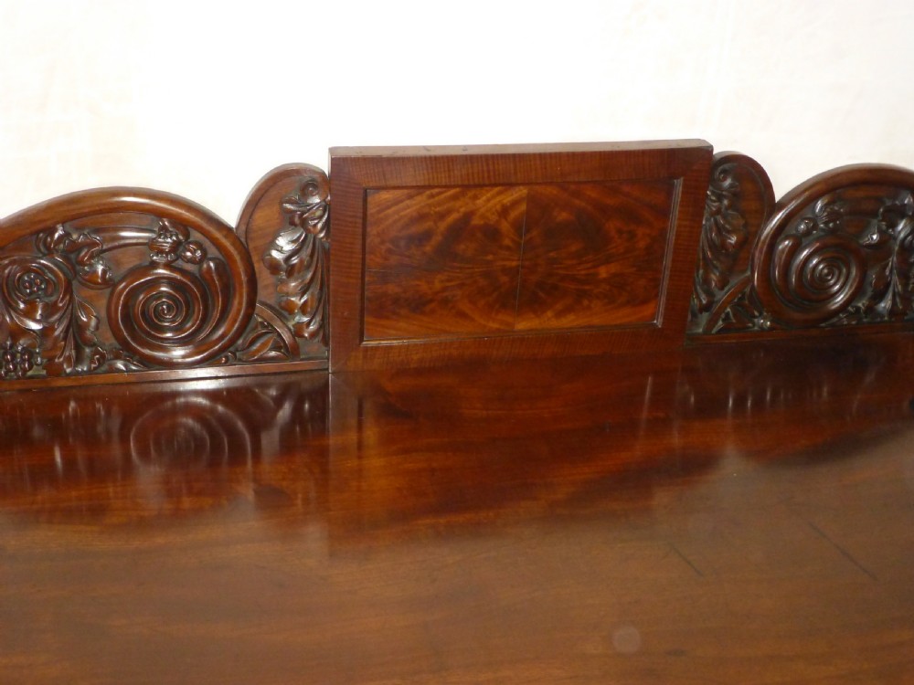 A dark mahogany Regency serving table featuring a scroll-carved backboard, a smooth top surface, and carved scroll front legs. View XI