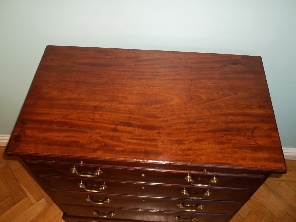 An eighteenth-century Georgian Cuban mahogany bachelors chest of drawers featuring an extended pull-out brushing slide and brass drop handles. View III