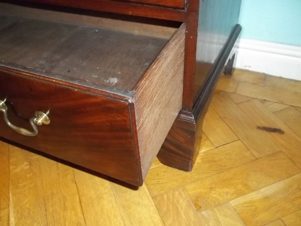 An eighteenth-century Georgian Cuban mahogany bachelors chest of drawers featuring an extended pull-out brushing slide and brass drop handles. View VI