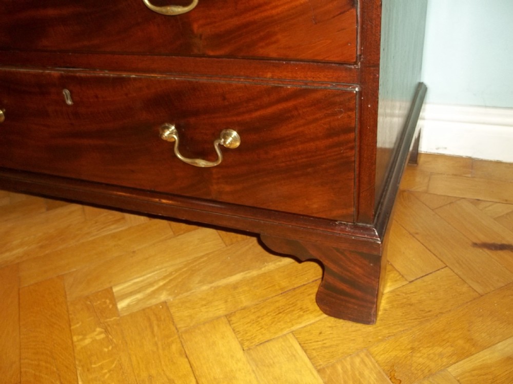An eighteenth-century Georgian Cuban mahogany bachelors chest of drawers featuring an extended pull-out brushing slide and brass drop handles. View VII