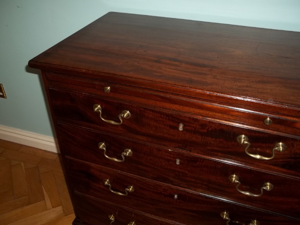 An eighteenth-century Georgian Cuban mahogany bachelors chest of drawers featuring an extended pull-out brushing slide and brass drop handles. View VIII