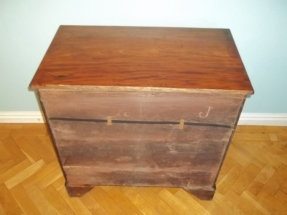 An eighteenth-century Georgian Cuban mahogany bachelors chest of drawers featuring an extended pull-out brushing slide and brass drop handles. View X