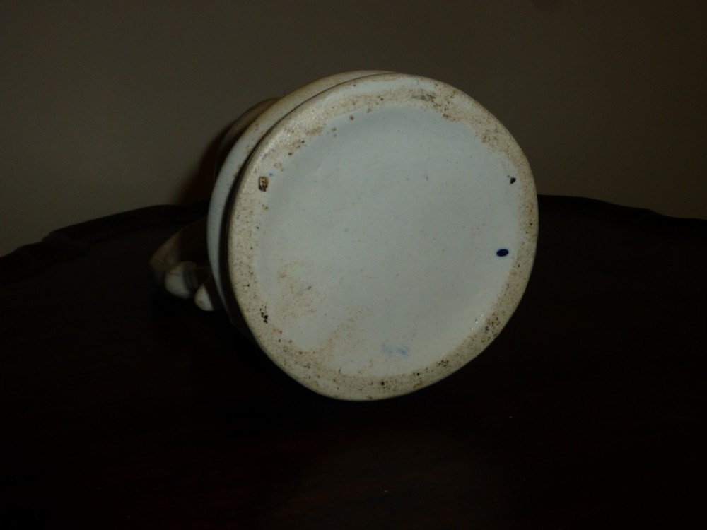A white ceramic Staffordshire milk jug featuring raised relief mouldings and hand-painted cobalt blue scroll accents. View IV